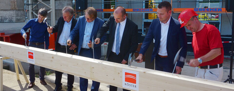 Foto v. l.: Tragwerksplaner Nico Beuche, Architekt Jörg Huhnholz, Bauherr Andreas Harder, Geschäftsführer des Flughafen Leipzig/Halle Johannes Jähn, Plateno-Vizechef Bastian Erfurth und unser Polier Ralf Zimmermann schlagen die letzten Sparrennägel ein.