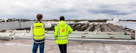 Björn Evers, Leitung Werkplanung bei Claas, und Stefan Bastian, Projektleiter bei Köster am Standort Bielefeld, (v.l.n.r.) besprechen die Baumaßnahme auf dem Dach einer Produktionshalle am Claas-Standort in Harsewinkel. 